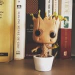 Cute baby groot planter in a white pot with some books behind
